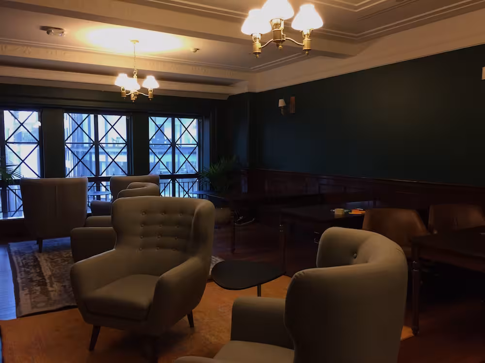 Image 3: A room with leather chairs and mahogany desks