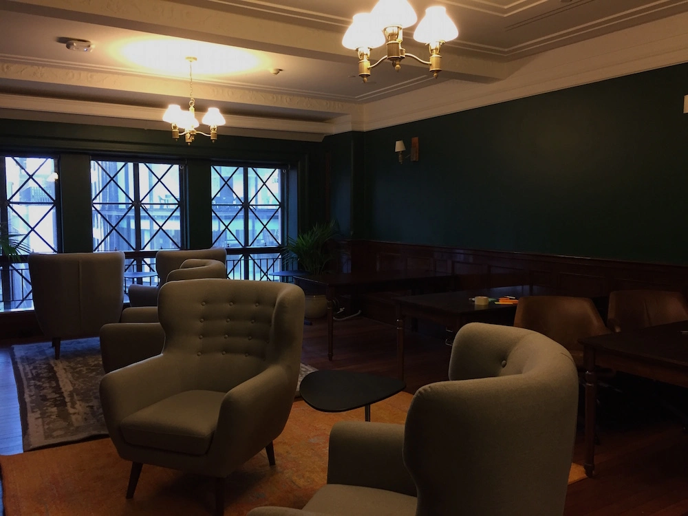 Image 3: A room with leather chairs and mahogany desks