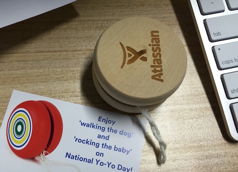 Image 1: A yo-yo I received from Atlassian. Card next to it says walk the dog and rock the baby.